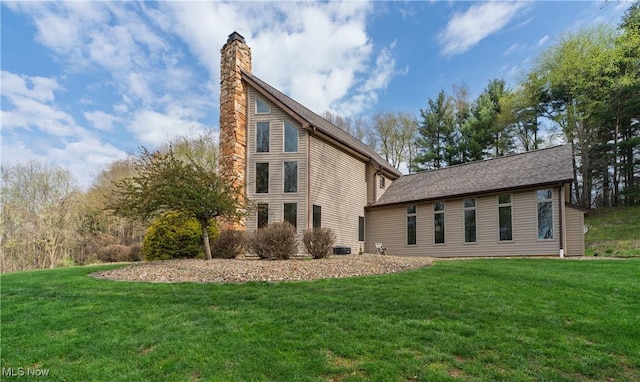 back of house with a chimney and a yard