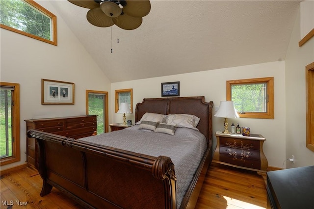 bedroom with high vaulted ceiling, ceiling fan, and hardwood / wood-style flooring