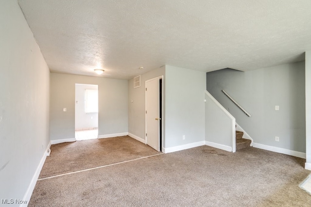 unfurnished living room featuring a textured ceiling, visible vents, stairway, baseboards, and carpet