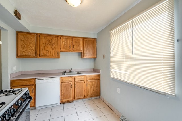 kitchen featuring light countertops, brown cabinets, range with gas cooktop, a sink, and dishwasher