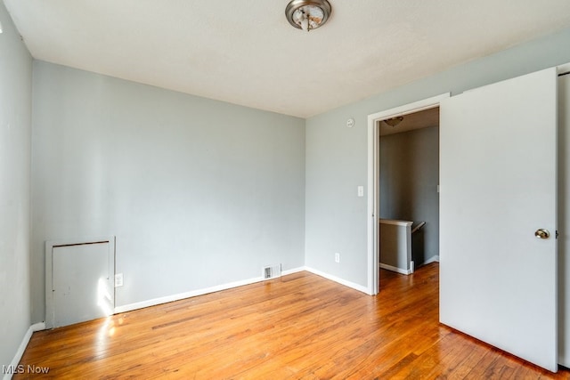 unfurnished bedroom with baseboards and wood finished floors