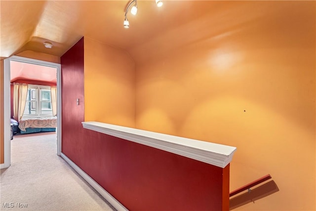corridor with carpet flooring and vaulted ceiling