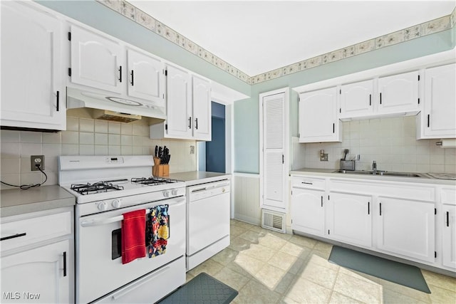 kitchen featuring visible vents, white appliances, under cabinet range hood, white cabinets, and a sink