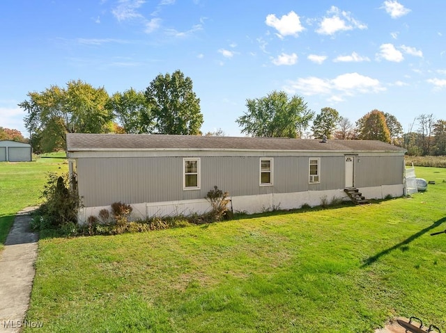 back of house featuring a lawn and entry steps