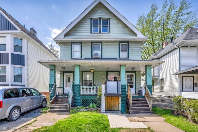 american foursquare style home featuring covered porch
