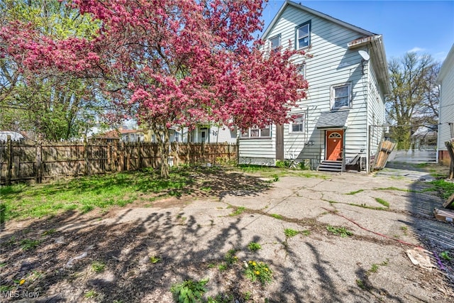 back of property featuring entry steps and fence