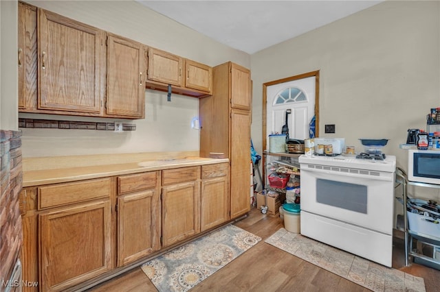 kitchen featuring white appliances, light countertops, and light wood-style floors