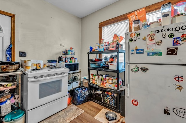 kitchen with white appliances and wood finished floors