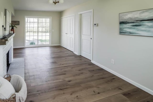 interior space with baseboards, wood finished floors, and a fireplace