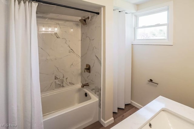 bathroom featuring baseboards, shower / bathtub combination with curtain, and wood finished floors