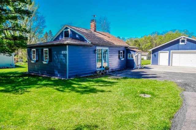 view of home's exterior featuring an outdoor structure, roof with shingles, a chimney, a lawn, and a detached garage