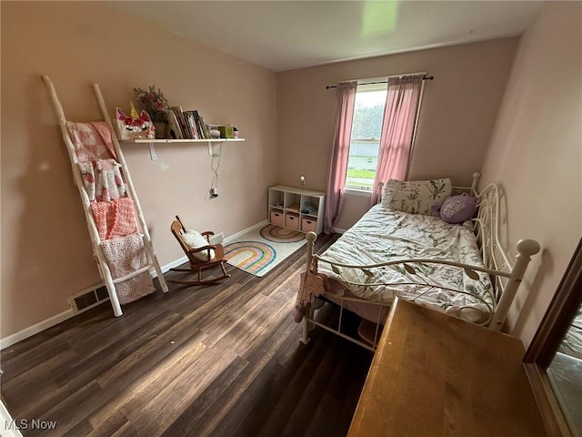 bedroom featuring baseboards, visible vents, and wood finished floors