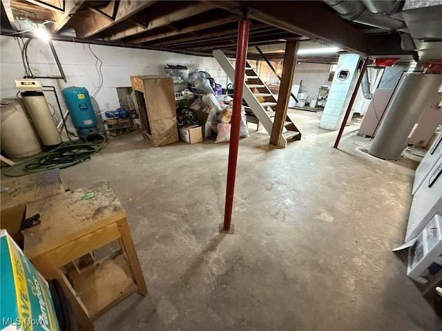unfinished below grade area featuring stairway and concrete block wall