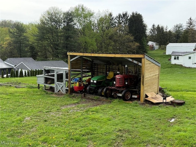 view of outdoor structure featuring a carport and an outbuilding