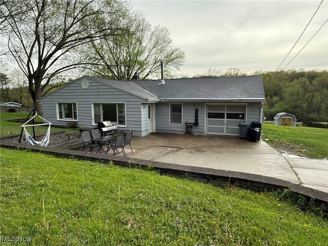 rear view of property with an attached garage, a yard, a deck, and concrete driveway