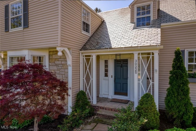 view of exterior entry with a high end roof