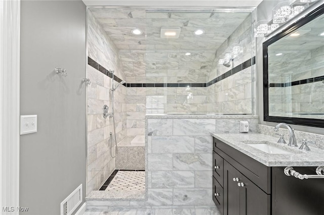 full bathroom with a walk in shower, visible vents, and vanity