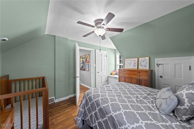 bedroom featuring baseboards, a ceiling fan, wood finished floors, and vaulted ceiling