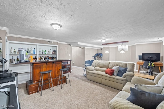living area featuring visible vents, crown molding, a dry bar, baseboards, and light carpet