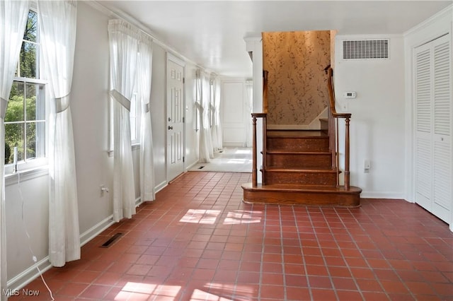 stairs with tile patterned floors, ornamental molding, and visible vents