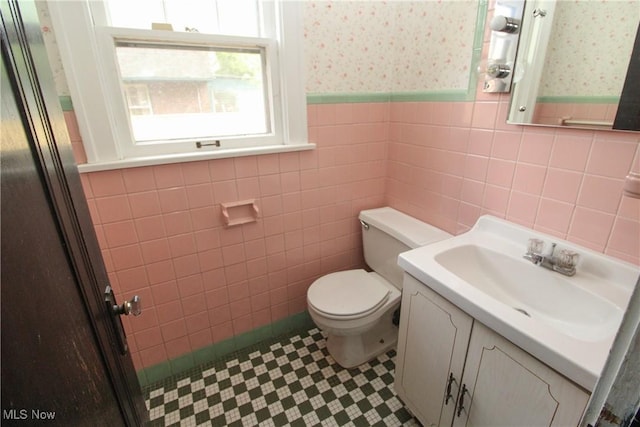 132 Jennette Dr, Boardman, OH 44512 - bathroom featuring tile walls, wainscoting, vanity, toilet, and wallpapered walls