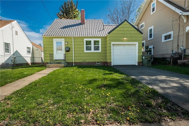 view of front of home with fence, an attached garage, a front yard, a tiled roof, and driveway