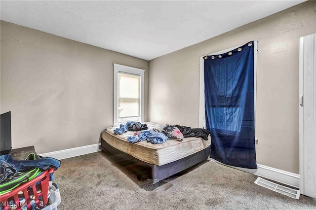 carpeted bedroom with baseboards and visible vents