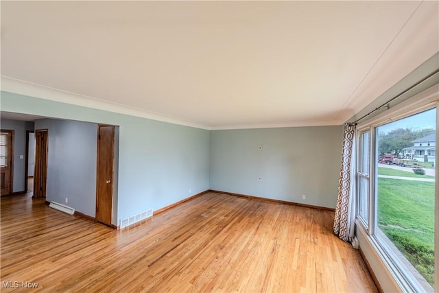unfurnished room featuring light wood finished floors, baseboards, a baseboard radiator, visible vents, and ornamental molding