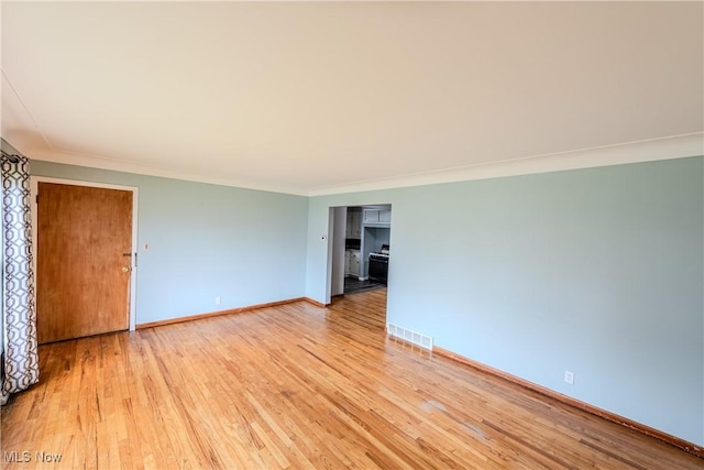 unfurnished room featuring baseboards, visible vents, ornamental molding, and light wood finished floors