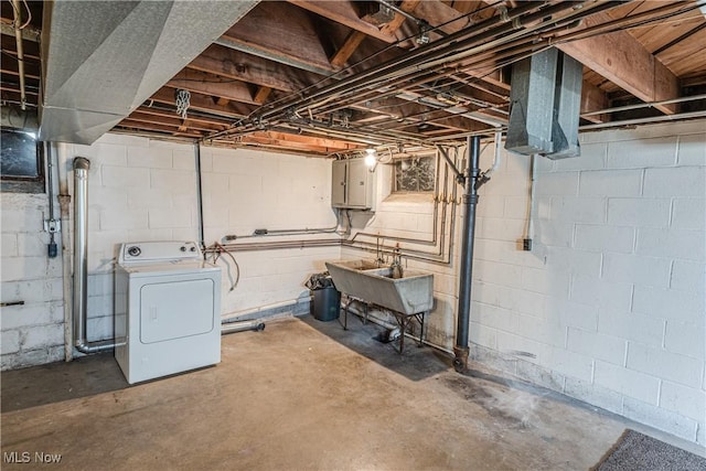 unfinished below grade area with a sink and washer / clothes dryer