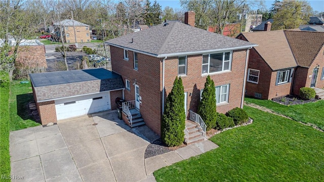 exterior space with a front yard, a chimney, brick siding, a shingled roof, and driveway