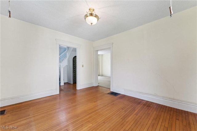 162 S Cedar St, Oberlin, OH 44074 - empty room with light wood finished floors, baseboards, and arched walkways