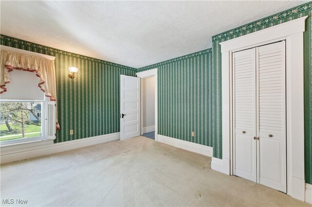 162 S Cedar St, Oberlin, OH 44074 - unfurnished bedroom with carpet, a textured ceiling, a closet, wallpapered walls, and baseboards