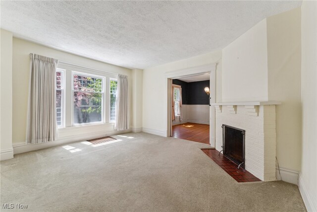 162 S Cedar St, Oberlin, OH 44074 - unfurnished living room with carpet flooring, a textured ceiling, and a brick fireplace