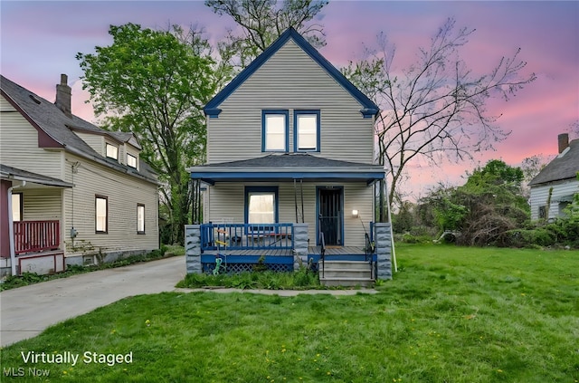 view of front of house with a porch and a lawn