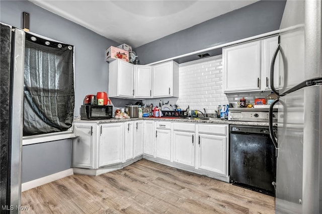 kitchen featuring light wood-style floors, freestanding refrigerator, white cabinetry, and black dishwasher