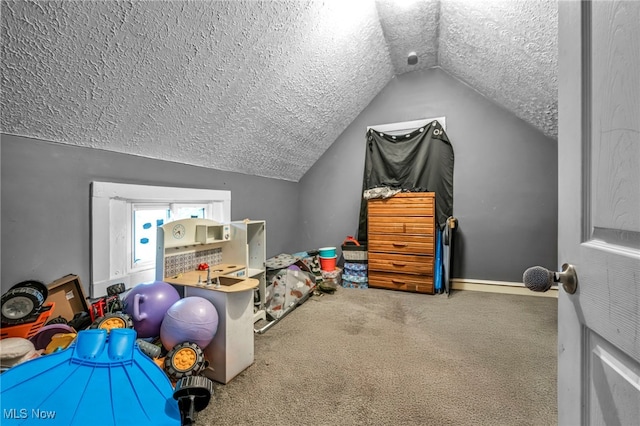 playroom with carpet, a textured ceiling, and lofted ceiling