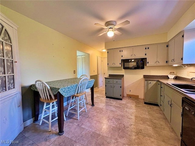kitchen featuring ceiling fan, dark countertops, a sink, and black appliances