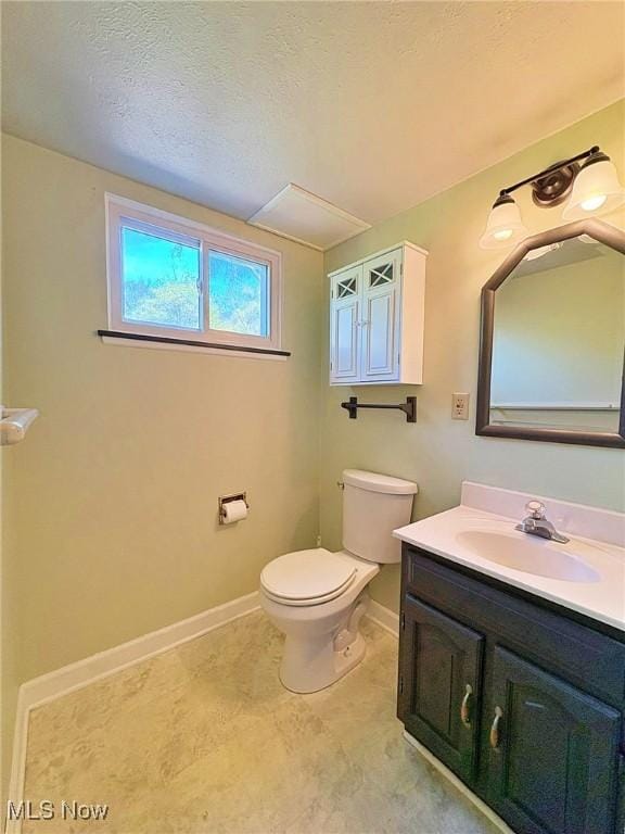 bathroom with toilet, baseboards, a textured ceiling, and vanity