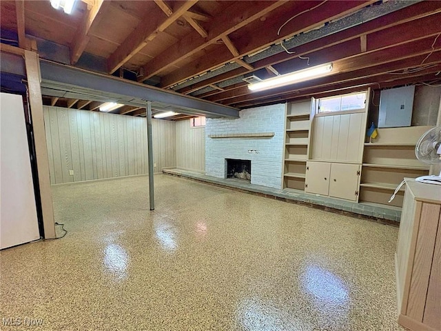 below grade area with a fireplace, wooden walls, and electric panel