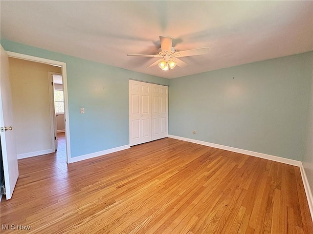 unfurnished bedroom with light wood-type flooring, baseboards, and a closet