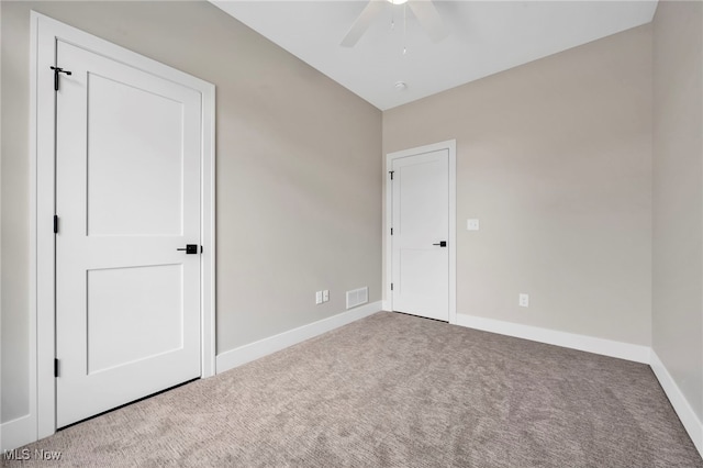 unfurnished bedroom with carpet flooring, baseboards, visible vents, and ceiling fan
