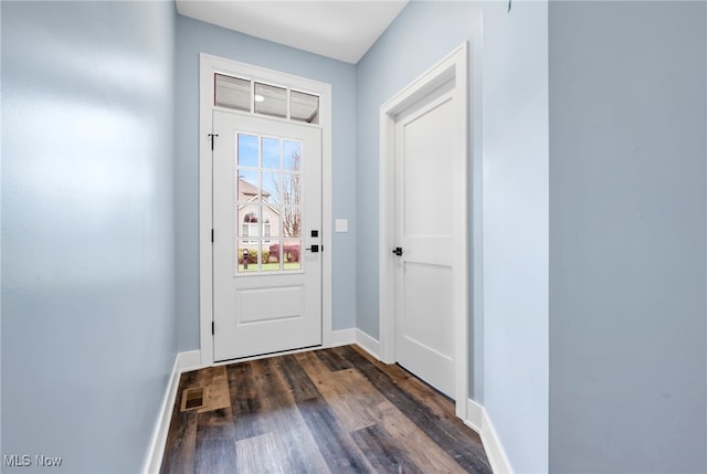 doorway to outside with dark wood-type flooring, baseboards, and visible vents