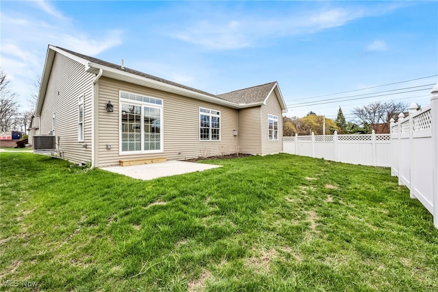 rear view of property with fence, a patio, a yard, and central AC unit