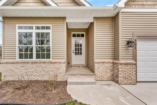 entrance to property featuring brick siding and an attached garage
