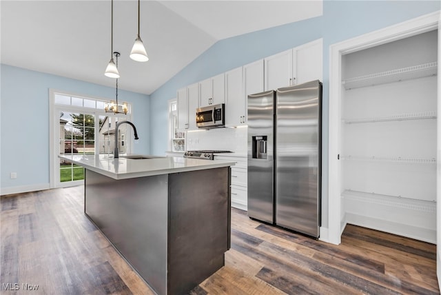kitchen with a sink, a center island with sink, white cabinets, and stainless steel appliances