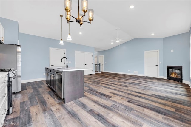 kitchen with ceiling fan with notable chandelier, dark wood-type flooring, light countertops, a sink, and appliances with stainless steel finishes
