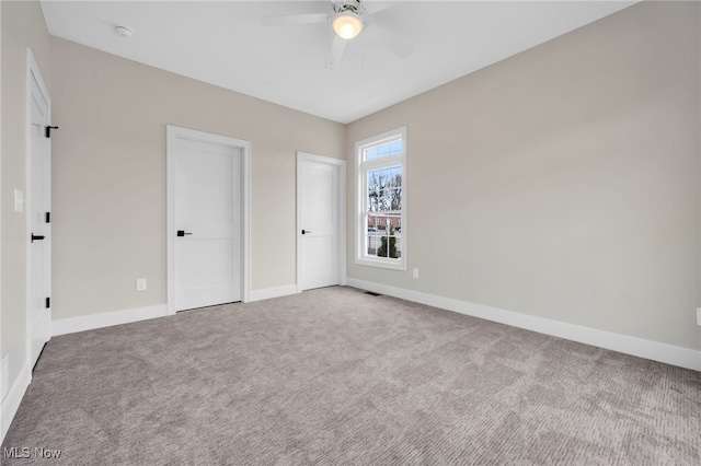 unfurnished bedroom featuring baseboards, a ceiling fan, and carpet