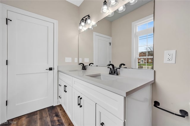 bathroom featuring double vanity, a sink, and wood finished floors