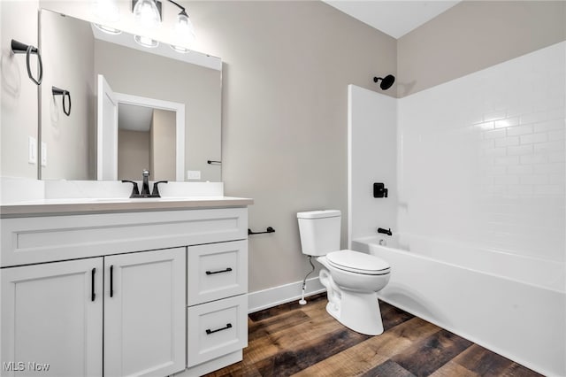bathroom with shower / tub combination, wood finished floors, vanity, baseboards, and toilet